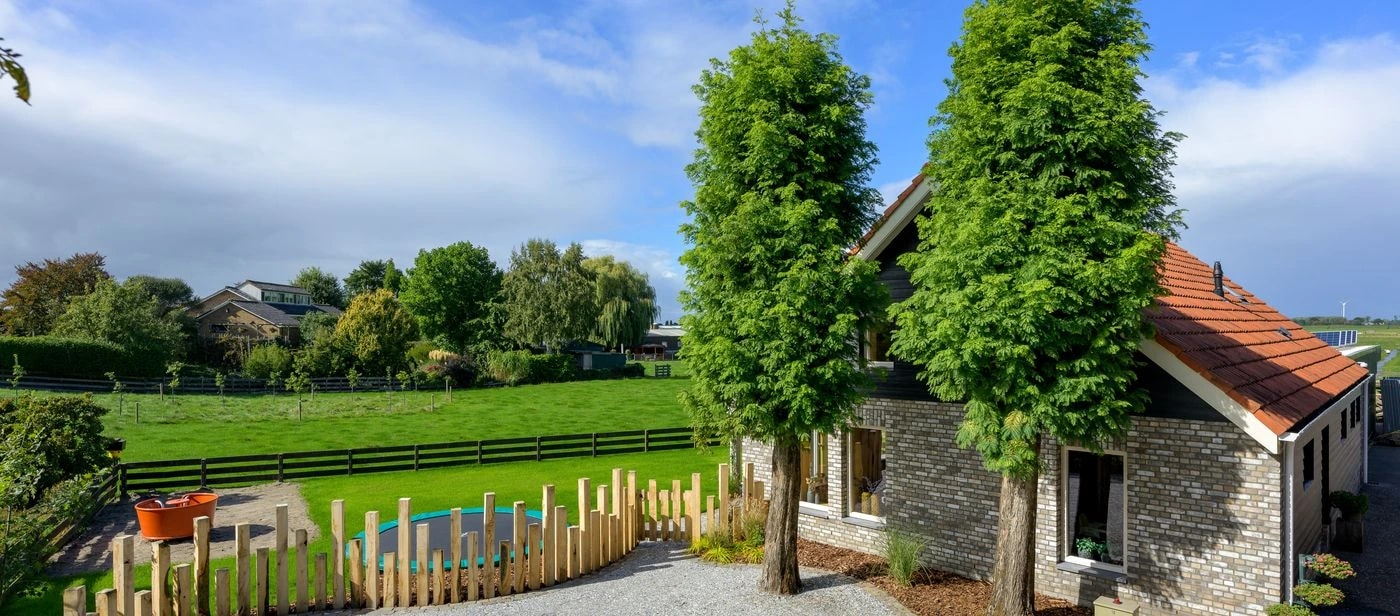 Vakantieboerderij De Veenderij met weiland en hoge bomen