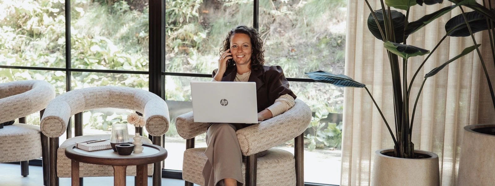 Georget belt met haar laptop op schoot in een fauteuil